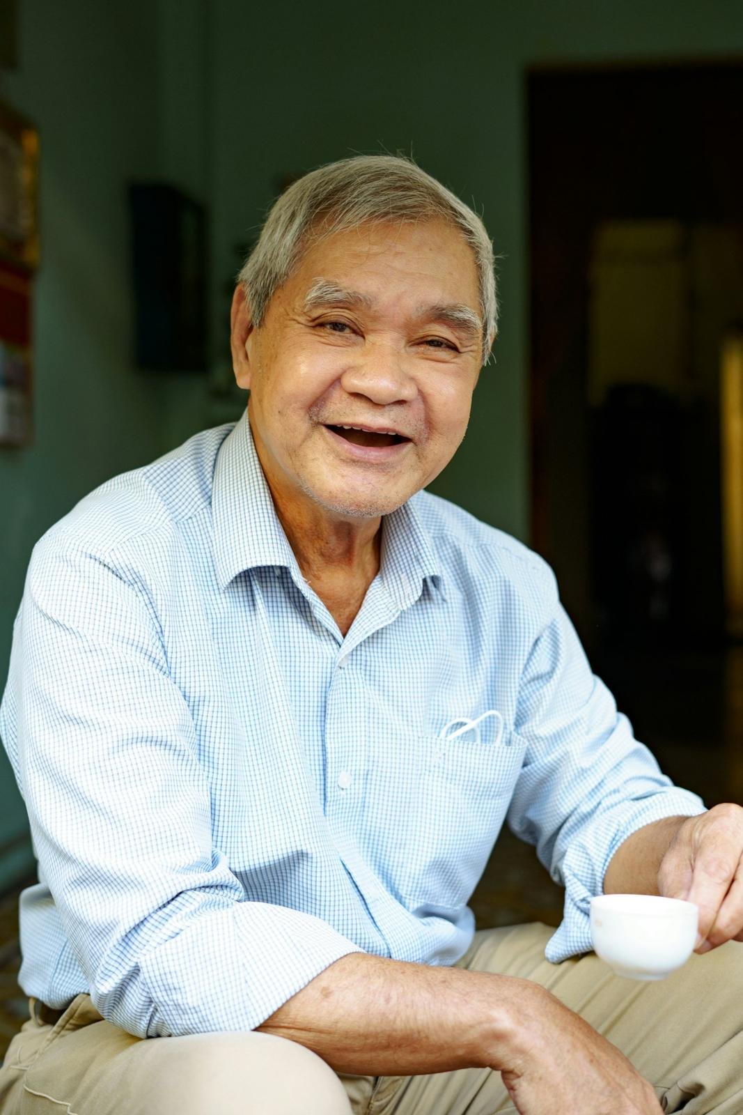 Smiling older man holding a cup of coffee