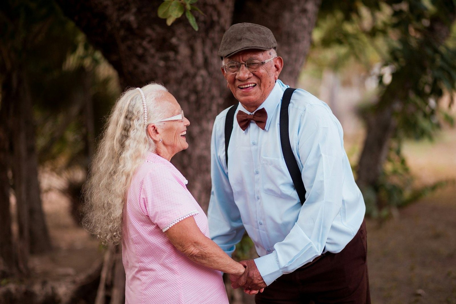 Smiling older couple holding hands in a garden