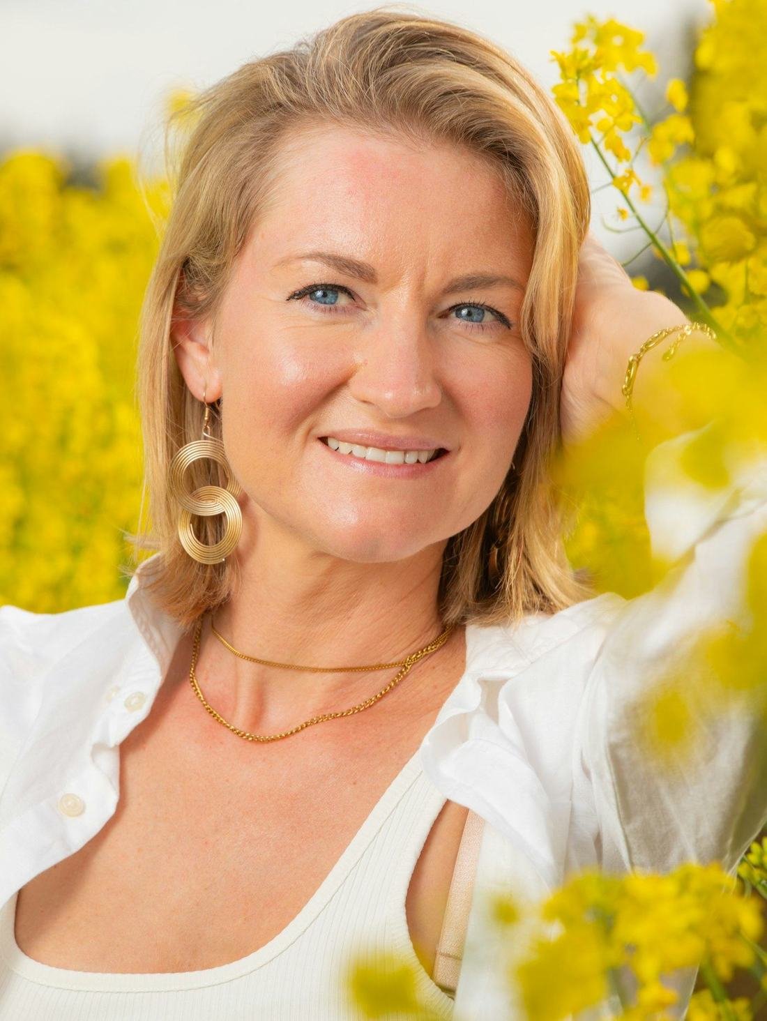 Smiling woman among yellow flowers